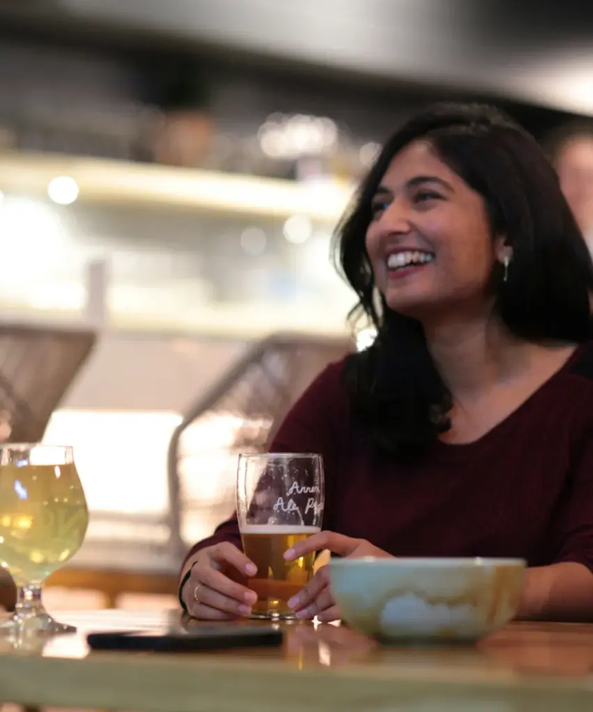 Lachende Frau mit Bierglas bei einem Tasting im Taproom