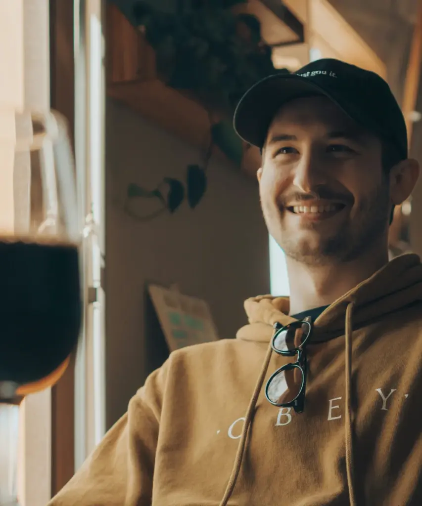 Gast lacht beim Biertasting zwischen den Kesseln der Brauerei
